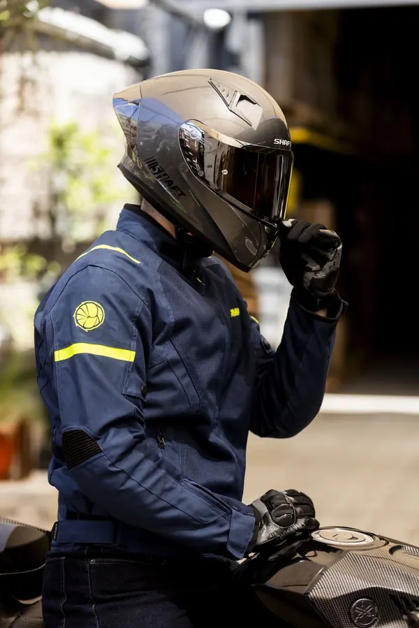 Motociclista quitándose el casco con la chaqueta ARMAD puesta